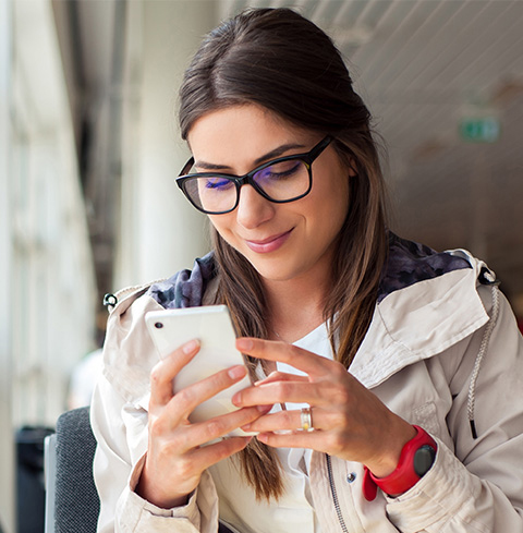  Une femme à lunettes tenant un téléphone mobile